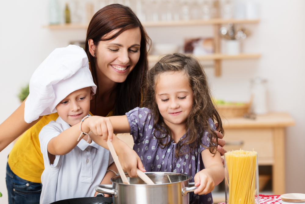 Mutter und Kinder kochen